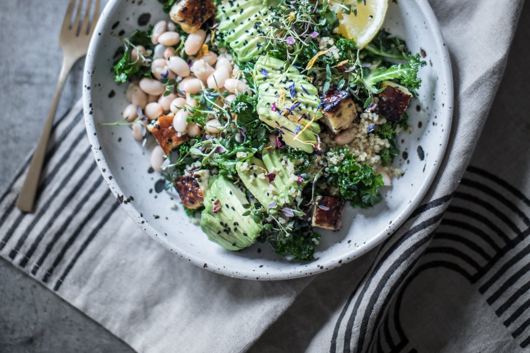 quick & easy vegan kale, white bean, and charred tempeh salad with avocado, quinoa, dukkah, and a lemony vinaigrette! This detox salad is dairy free, gluten free, healthy, and vegan, and it can be adapted to the keto, paleo, and whole 30 diets by omitting the quinoa and beans! You can even simmer it in stock to turn it into a soup!