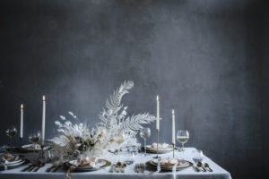 A minimalist, modern, neutral holiday tablescape for Christmas and your winter table setting with a natural, unique dried flower centerpiece, white linen table cloth, mini bouquet place settings, and brass gold flatware. It’s an elegant floral design, a DIY arrangement and homemade wreaths using pampas grass, bleached fern, tallow berry, bunny tail grass, and lunaria. Discover an organic, asymmetrical wreath tutorial along with a DIY Christmas cracker / popper how to, and sustainable gift wrapping ideas of muslin, linen, and upcycled paper with hand dyed silk ribbons and dried flower boutonniere gift toppers that can be reused year after year. By Beth Kirby | Local Milk Blog.
