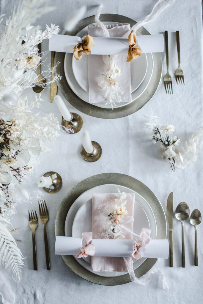 How to make handmade DIY Christmas Crackers with white paper & pink and mustard silk ribbons filled with confetti, paper crowns, jokes, and small gift ideas for you holiday dinner part tablesetting. They make great table name cards! Simple and easy with no pattern required! | photos & styling by Beth Kirby / Local Milk