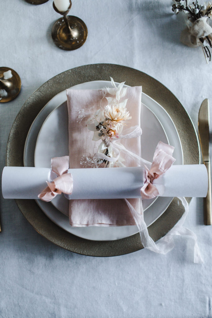How to make handmade DIY Christmas Crackers with white paper & pink and mustard silk ribbons filled with confetti, paper crowns, jokes, and small gift ideas for you holiday dinner part tablesetting. They make great table name cards! Simple and easy with no pattern required! | photos & styling by Beth Kirby / Local Milk