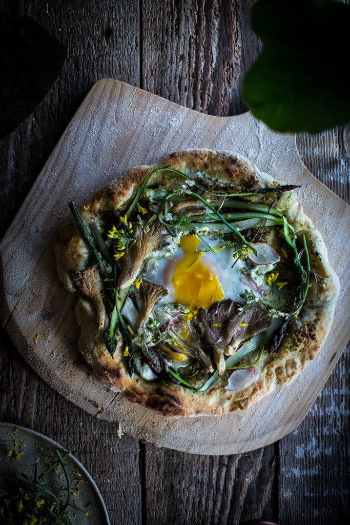 Garlic scape pesto flatbread with ricotta and asparagus topped with a runny egg